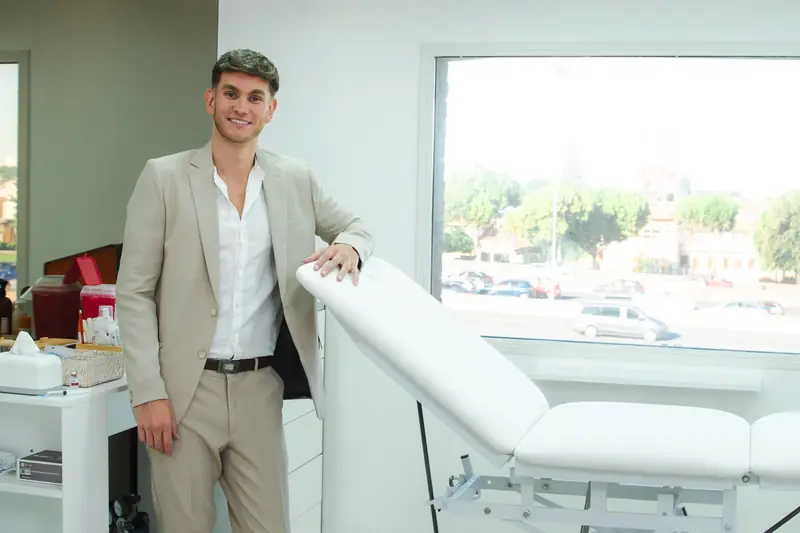 El Dr. Hener junto a la camilla del consultorio